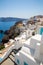 View of Fira town - Santorini island,Crete,Greece. White concrete staircases leading down to beautiful bay with clear blue sky and