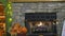 View of a Fireplace With a Fire, all Decorated for Autumn With Pumpkins, Scarecrows and Fall Leaves.