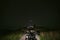 View from the first person. Motorcycle steering wheel. On a tourist motorbike in the middle of a mountain dirt road. The night is