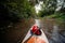 View from the first person. A trip on a SAP board. A narrow river in the middle of the forest, an extreme route. bag with water