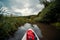 View from the first person. A trip on a SAP board. A narrow river in the middle of the forest, an extreme route. Waterproof bag.