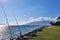 View of fishing rod anchored between rocks,  Hawaiian ocean, and an island seen from a park in Maui