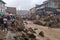 view of flash flood carrying debris through town, with people fleeing to safety