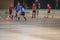 View of floorball match game, court hall indoor venue with junior teenage children school team playing in the background, floor