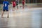 View of floorball match game, court hall indoor venue with junior teenage children school team playing in the background, floor