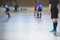 View of floorball match game, court hall indoor venue with junior teenage children school team playing in the background, floor