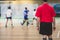 View of floorball match game, court hall indoor venue with junior teenage children school team playing in the background, floor