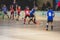 View of floorball match game, court hall indoor venue with junior teenage children school team playing in the background, floor