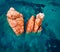 View from flying drone. Colorful summer view of Red Rocks Gli Scogli Rossi - Faraglioni on the di Cea beach. Aerial morning scene