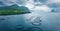 View from flying drone. Dramatic summer scene of Trollkonufingur cliffs on Vagar island. Gloomy morning view of fish farm on outsk