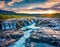 View from flying drone. Exciting summer sunrise on Bruarfoss Waterfall, secluded spot with cascading blue waters. Impressive morni