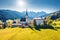 View from flying drone. Sunny morning scene of Pfarramt Catholic Church. Aerial autumn view of Gosau village in the district of Gm