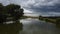 View flying over the pond by the agricultural fields under the cloudy sky