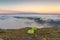View of a foggy landscape from Mount Aggie, Brindabella with green hiking tents near its edge