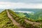 View of a footpath at the Miradouro da Grota do Inferno viewpoint leading towards one of the crater lakes at Sete Cidades