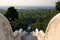 View on forest and Wat Yansangwararam temples and Pattaya city on the horizon from staircase.