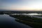 View of Fort Hamer Bridge and trees under the blue sky reflected in the water at sunset