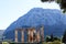 View of fortress Acrocorinth from ancient Corinth, Greece with pillars of Temple of Apollo in the foreground