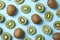 view of fresh whole and cut kiwis on light blue background