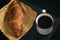 View of freshly baked croissant on a piece of newspaper with a cup of hot coffee simple morning breakfast copy space message