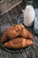 View of freshly baked croissants on wooden table with  bottle of milk in the background simple morning breakfast