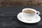 View of a freshly brewed mug of espresso coffee on rustic wooden background with woodgrain texture. Coffee break style, concept.