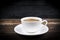 View of a freshly brewed mug of espresso coffee on rustic wooden background with woodgrain texture. Coffee break style, concept