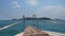 A view from the front of a boat deck. Seeing the tropical island and blue sky ahead