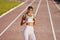 View from the front. Young woman in sportive clothes is exercising outdoors