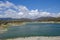 View of the germasogeia dam in Cyprus, taken on a bright blue sky day with beautiful clouds sitting above the mountains