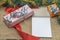 View of gifts packed in holiday boxes lying with pen and book desktop. Christmas holiday concept. Postcard.