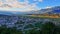 View of Gjirocaster city in shadow from Gjirocaster castle with green fields and monumental mountain ridge in the background