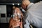 View through a glass with water in a Caucasian blonde woman hands on blurred background with a middle aged couple flirting