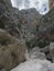 view of Gola Su Gorropu gorge with limestone rock walls, green bush and trees. Famous tourist hiking destination at