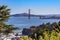 View of the Golden Gate bridge from Lands End cliffs with cypress trees, Pacific Ocean in background in San Francisco CA