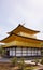 View of golden pavilion of Kinkakuji temple with clouds in blue sunny sky