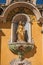 View of golden sculpture in niche of church facade of Vence.