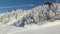 View of gondola lift with snow covered mountains, gondola above ski slope