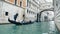 View of gondola with tourists under the Bridge of Sighs in Venice, rainy day