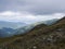 View from grassy hill slopes of hiking trail from Chopok at mountain meadow ridge Low Tatras mountains, Slovakia. Fog