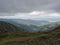 View from grassy hill slopes of hiking trail from Chopok at mountain meadow ridge Low Tatras mountains, Slovakia. Fog