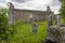 A view through grave stone and foliage of the abanoned ruins of Killone Abbey that was built in 1190 and sits on the banks of the