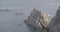 View of a great formation of rocks near the sea with a boat sailing in the right side