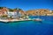 View on Greek sea Simy island harbor port, classical ship yachts, houses on island hills, tourists Aegean Sea bay. Greece islands