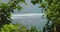 View through the green bushes to the azure sea. Green Bowl Beach in Bali Island. Ocean waves splash and crash on shore