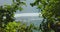 View through the green bushes to the azure sea. Green Bowl Beach in Bali Island. Ocean waves splash and crash on shore