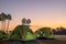 A view of a green canvas camping tent illuminated by floodlights set up on the lawn