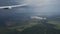 View of green landscape from airplane flight, clouds formations of rainy fall land