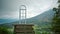 View of a green mountain from the far covered by fog and clouds with a standing door