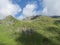 View on green mountain peaks with water streams from melting snow, summer sunny day, blue sky white clouds. Tirol